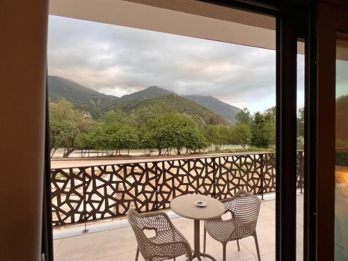 a balcony with a table and chairs and mountains at The Mark Hotel in Gliki