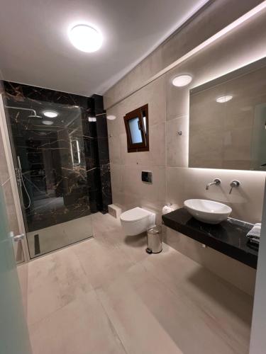 a bathroom with a sink and a toilet and a shower at The Mark Hotel in Gliki