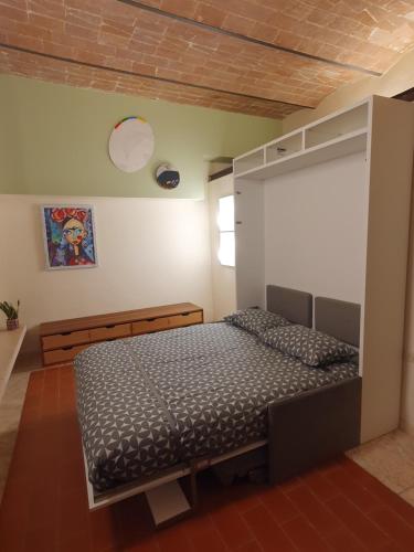ein Schlafzimmer mit einem Bett in einem Zimmer in der Unterkunft Baccio - studio apartment in Montelupo Fiorentino