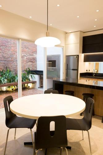 a kitchen and dining room with a white table and chairs at Lola’s home in Asuncion