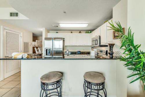 a kitchen with a counter and two bar stools at Calypso Resort & Towers in Panama City Beach