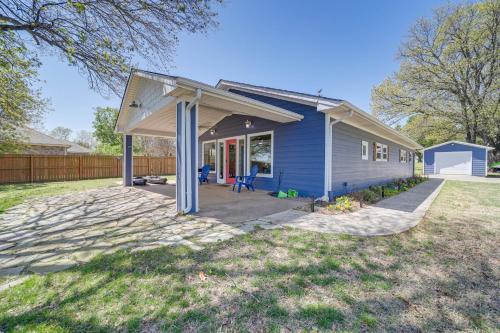 una casa azul con toldo en un patio en Lakefront Eufaula Cabin with Fire Pit and Private Dock, en Eufaula