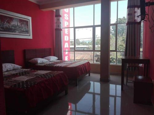 sypialnia z 2 łóżkami i dużym oknem w obiekcie Hostal Los Angeles w mieście Tarapoto