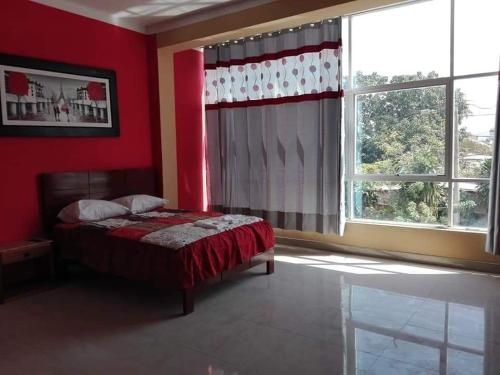sypialnia z łóżkiem i dużym oknem w obiekcie Hostal Los Angeles w mieście Tarapoto