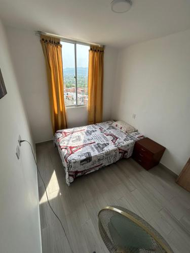 a small bedroom with a bed and a window at Reserva Del Peñon in Girardot