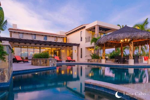 a swimming pool in front of a house at Firepit Sunsets, Hot Tub Soaks, BBQ, Ocean Views in San José del Cabo