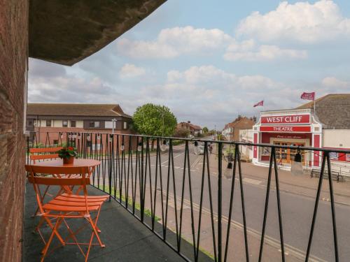 a table and a chair on a balcony with a street at The Upper Circle in Clacton-on-Sea