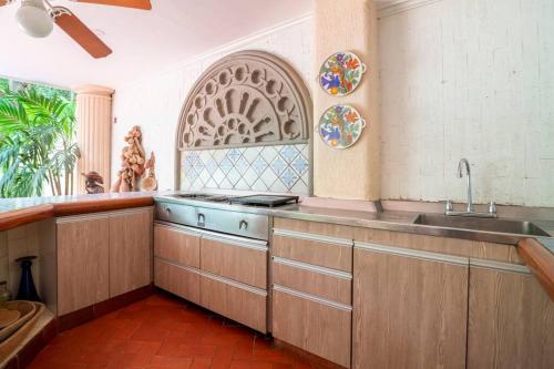 a kitchen with wooden cabinets and a sink and a window at El Refugio Beach House, Bello Horizonte, Santa Marta in Playa Dormida