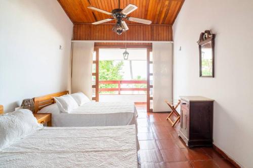 a bedroom with two beds and a ceiling fan at El Refugio Beach House, Bello Horizonte, Santa Marta in Playa Dormida