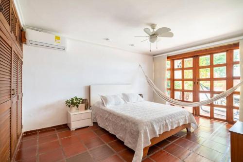 a bedroom with a bed and a ceiling fan at El Refugio Beach House, Bello Horizonte, Santa Marta in Playa Dormida