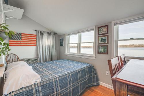 um quarto com uma cama e uma bandeira americana na parede em Quiet Plymouth Cottage on Great South Pond! em Plymouth