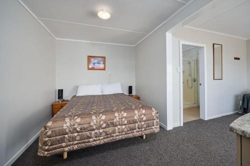 a bedroom with a bed in a white room at Sea View Motel - Unit 6 in Kaikoura