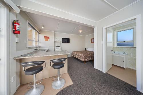 une chambre d'hôtel avec un lavabo et une chambre dans l'établissement Sea View Motel - Unit 6, à Kaikoura