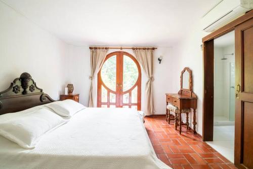 a bedroom with a large bed and a window at El Refugio Beach House, Bello Horizonte, Santa Marta in Playa Dormida