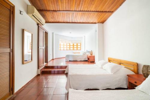 a bedroom with two beds and a wooden ceiling at El Refugio Beach House, Bello Horizonte, Santa Marta in Playa Dormida