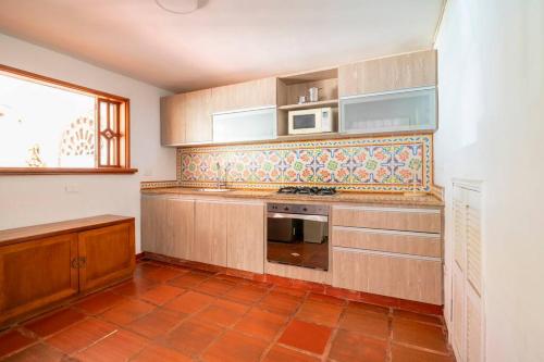 a kitchen with a stove and a microwave at El Refugio Beach House, Bello Horizonte, Santa Marta in Playa Dormida