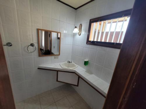 Baño blanco con lavabo y espejo en Pura Vida Dream en San José