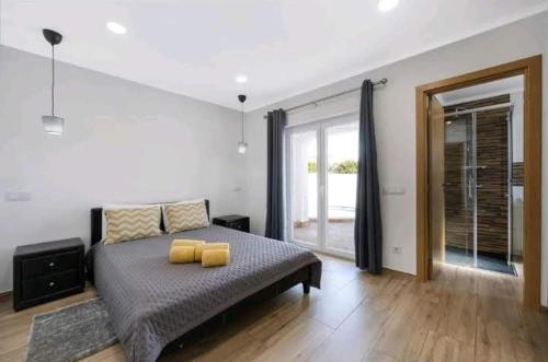 a bedroom with a bed with yellow pillows on it at Casa Serra e Mar in Luz