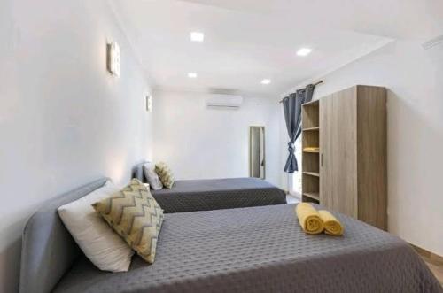 a bedroom with two beds with yellow slippers on it at Casa Serra e Mar in Luz