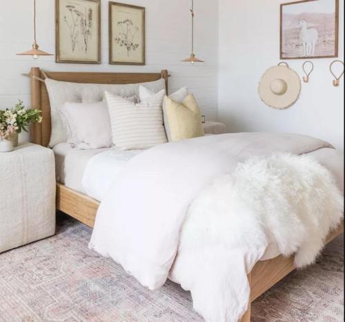 um quarto com uma cama grande com lençóis brancos e almofadas em House in the middle of Malmö em Malmo