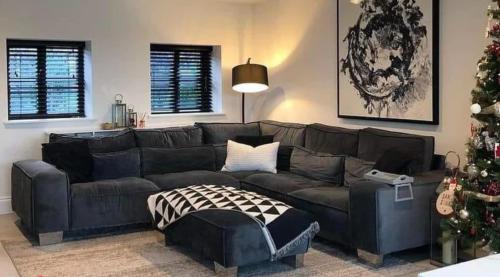 uma sala de estar com um sofá preto e uma árvore de Natal em House in the middle of Malmö em Malmo