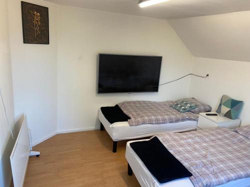 a room with two beds and a flat screen tv at Billund star in Brande