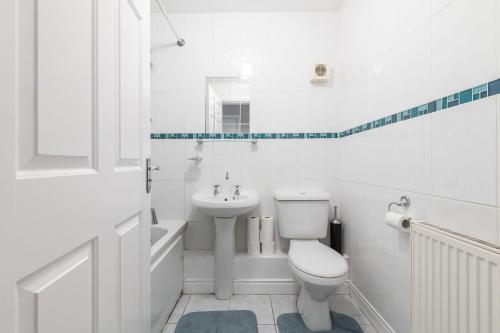 a white bathroom with a toilet and a sink at Holywell Rise Swords in Swords