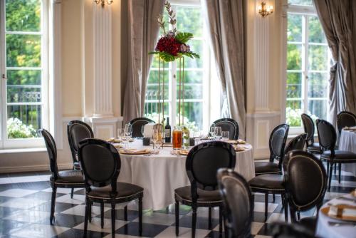 - une salle à manger avec une table, des chaises et des fenêtres dans l'établissement Hotel Pałac Alexandrinum, à Krubki