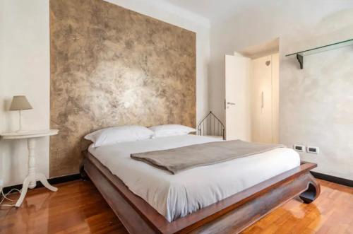 a bedroom with a large bed and a wall at Mydollhouse delizioso appartamento fronte mare in Genoa