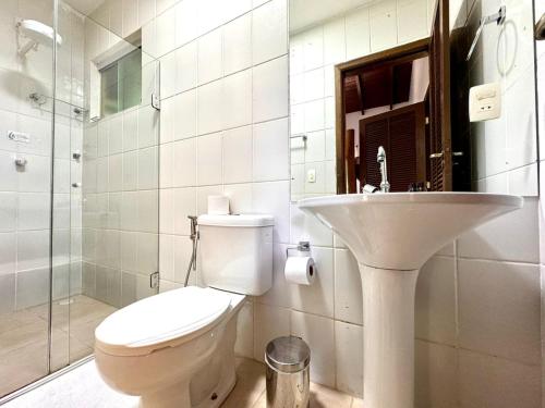 a white bathroom with a toilet and a sink at Pousada do Riacho Trindade in Trindade