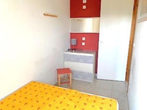 a room with a bed and a kitchen with red cabinets at Maison Salavas, 3 pièces, 4 personnes - FR-1-697-31 in Salavas