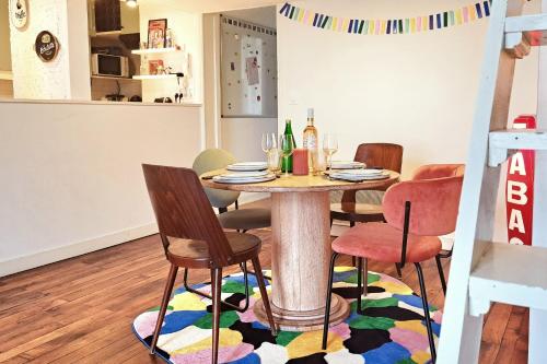 une salle à manger avec une table et des chaises sur un tapis dans l'établissement Charming apartment in Nantes, à Nantes