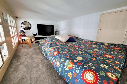 une chambre avec un lit avec une couette colorée dans l'établissement Charming apartment in Nantes, à Nantes