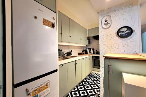 eine Küche mit weißen Schränken und einem Kühlschrank in der Unterkunft Charming apartment in Nantes in Nantes