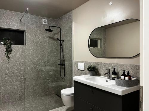 a bathroom with a shower and a sink and a mirror at Apartments in Hofn in Höfn