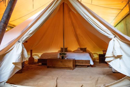 1 dormitorio en una tienda de campaña con 1 cama y 1 mesa en Seren Glamping, en Uvita