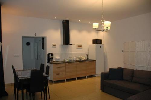 a living room with a couch and a kitchen at Blu Apartament in Strzelno