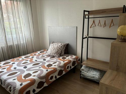 ein Schlafzimmer mit einem Bett mit einem Kissen darauf in der Unterkunft La Maison du Bonheur in Saint-Herblain