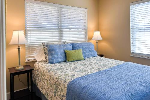 a bedroom with a bed with blue sheets and two lamps at Sunset Cove in Maynardville