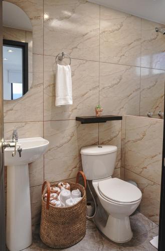 a bathroom with a toilet and a sink at Hotel Villa Del Sol in Marquetalia