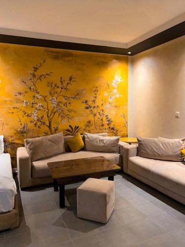 a living room with couches and a painting on the wall at La Suite Hotel Agadir Adults Only in Agadir
