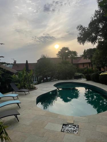 une petite piscine avec un coucher de soleil en arrière-plan dans l'établissement Gîte dans ferme rénovée 4-5 personnes, à Aubarède