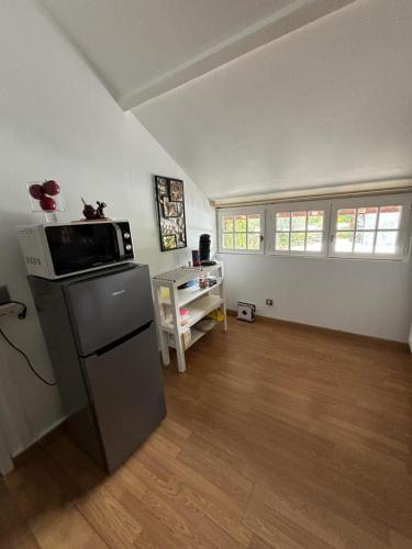 une chambre vide avec une cuisine équipée d'un réfrigérateur dans l'établissement Gîte dans ferme rénovée 4-5 personnes, à Aubarède