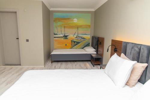 SazlıにあるKayalar Blue Beach Hotelのベッドルーム1室(ベッド1台付)が備わります。壁には絵画が飾られています。