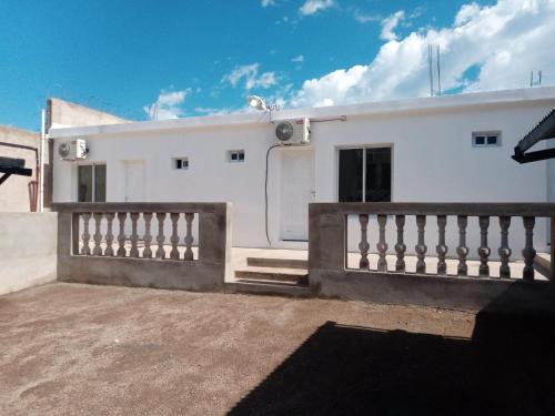 a white house with a fence in front of it at Hostal Peregrino II in San Luis