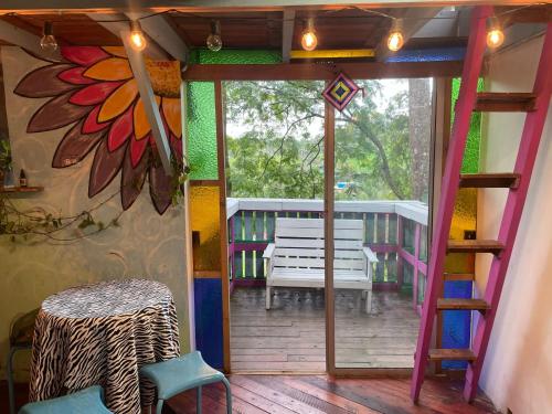 a room with a balcony with a door and a bench at CENTRO HOLISTICO ALLPA SAMAY in Puentetierra