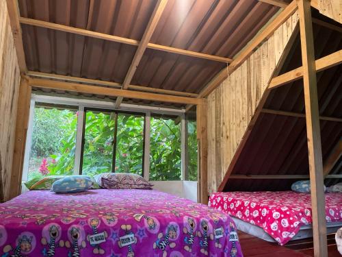 a room with a bed and a large window at CENTRO HOLISTICO ALLPA SAMAY in Puentetierra