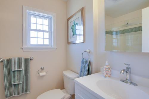 a bathroom with a sink and a toilet and a window at Charming Home with Yard Steps to Pawcatuck River! in Pawcatuck