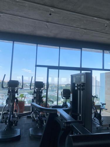 a gym with cardio equipment in front of a large window at Departamento en Zona Real/Acueducto in Guadalajara