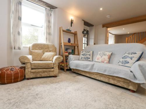a living room with a couch and a chair at Woodbine Cottage in Falmouth